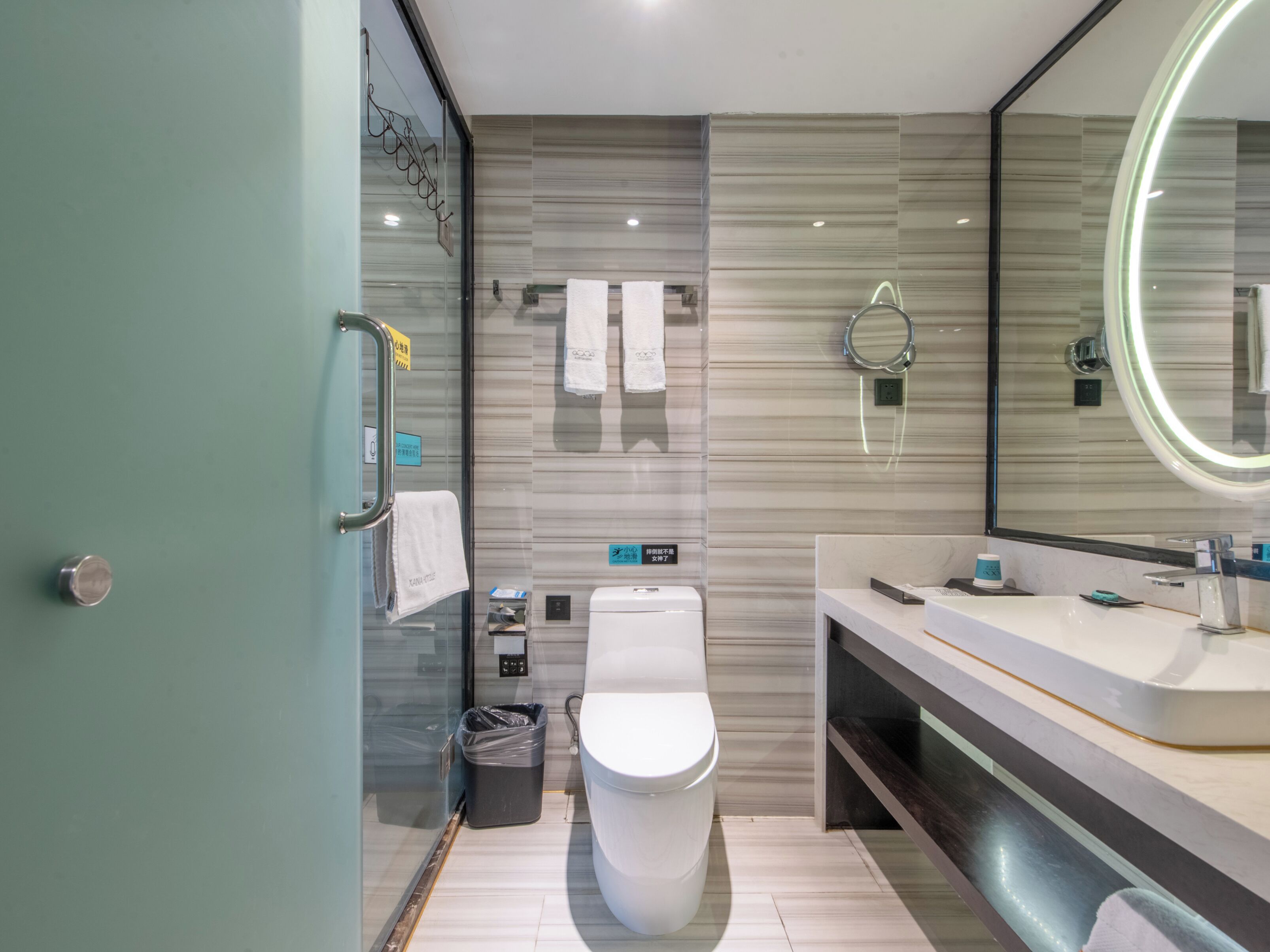 Un baño moderno con inodoro, bidé y un espejo grande.