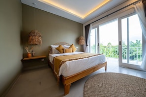 A bedroom with a bed, bedside tables, a large window, and a view of greenery.