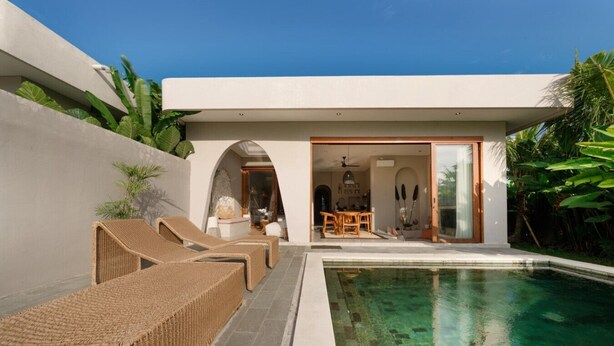 A modern outdoor pool area with lounge chairs, a dining area, and a clear view of the pool. - Villa Glentana - 3BR EPIC Sunset Villa (Seseh)