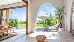 A modern interior with a dining area, a lounge with a hammock, and a view of a lush garden. - Villa Glentana - 3BR EPIC Sunset Villa (Seseh)