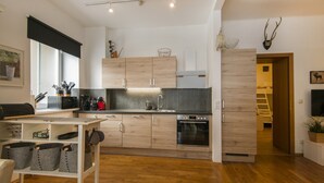 Una cocina moderna con armarios de madera, horno integrado y comedor con mesa y sillas.