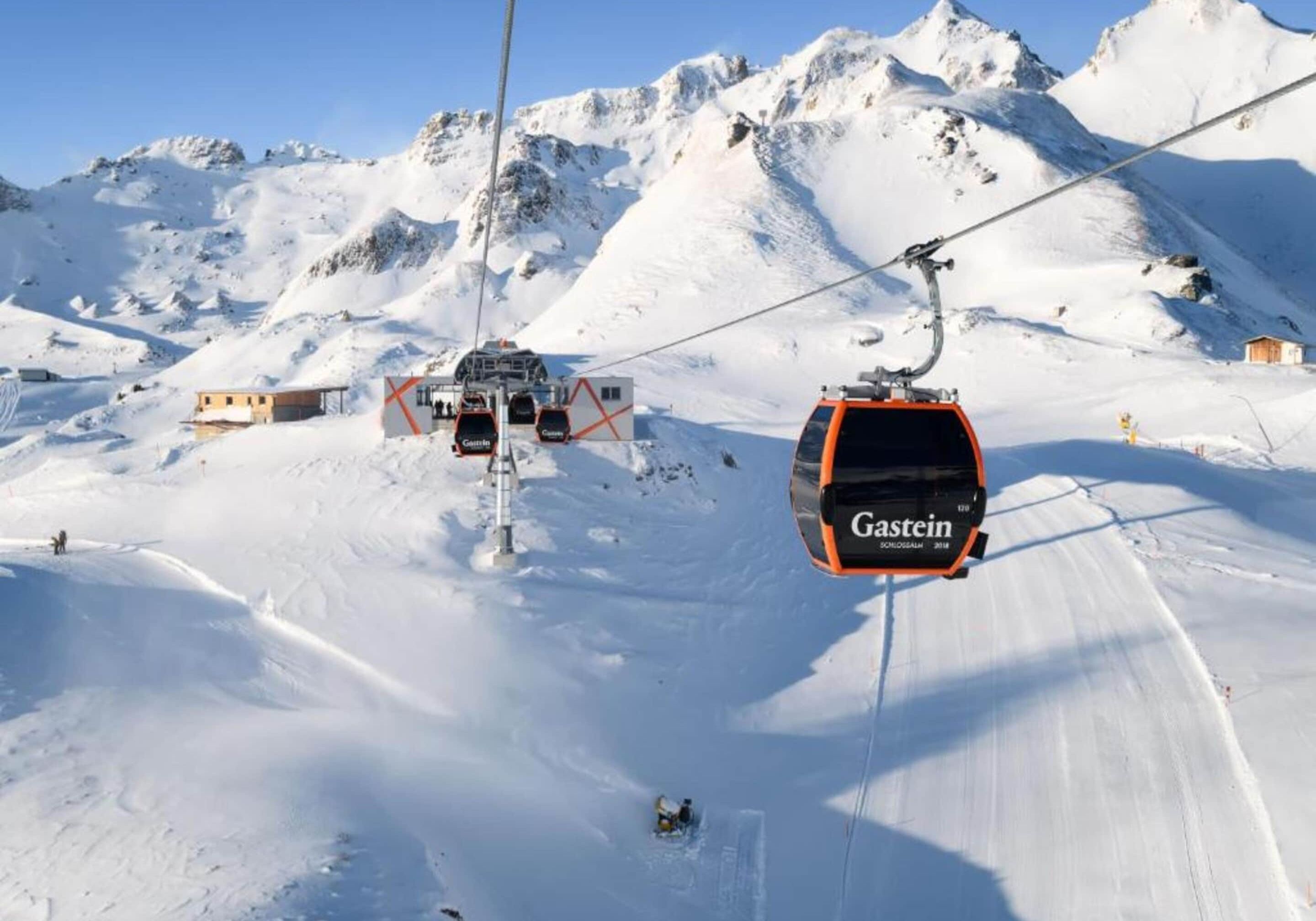 Ein Sessellift in einem Skigebiet mit einem Schild mit dem Schriftzug 'Gastein'.