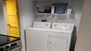 Une petite buanderie équipée d’un lave-linge, d’un sèche-linge et d’une cuisinière.