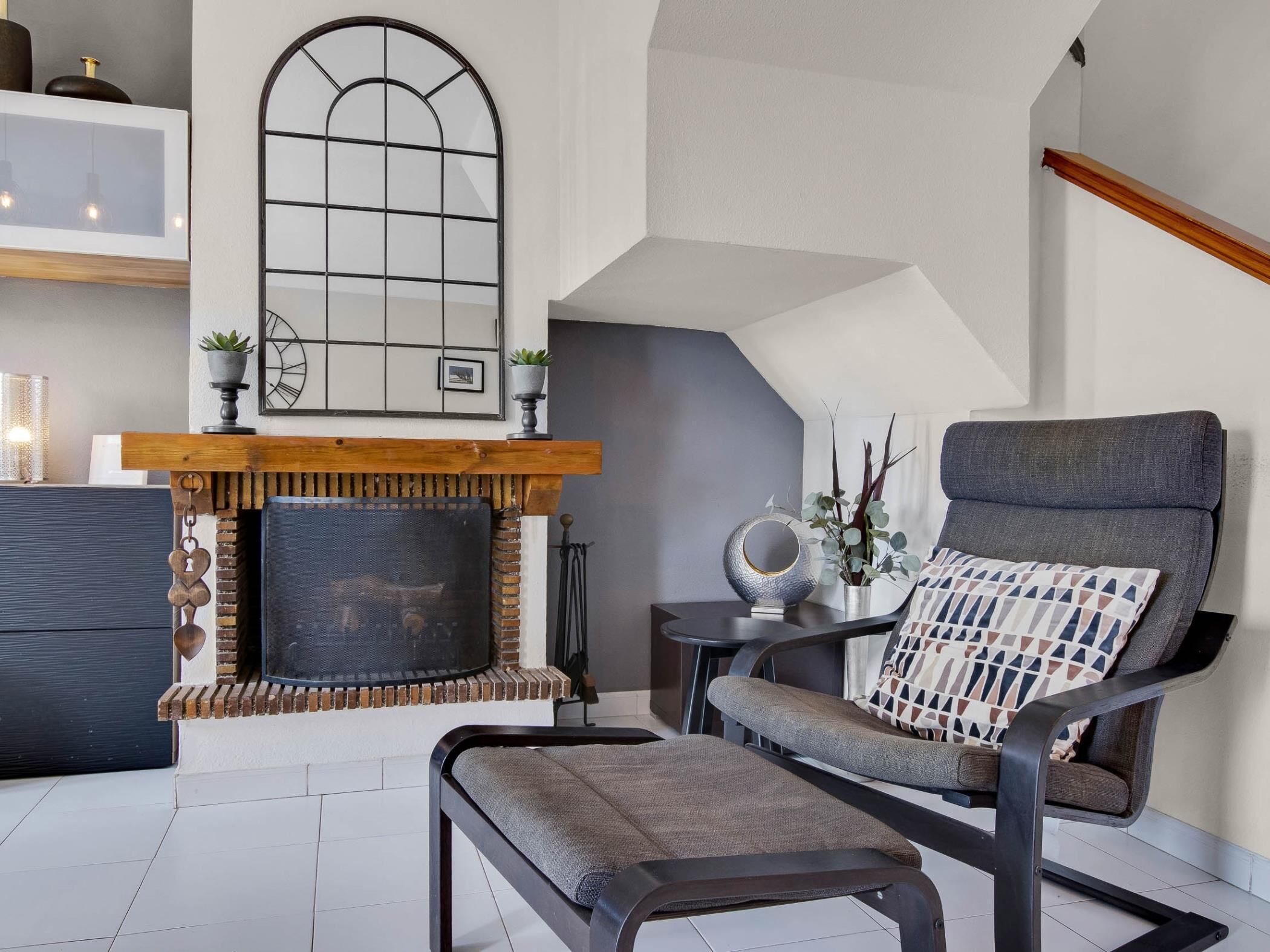 Una sala de estar moderna con chimenea, un sillón cómodo y una mesita.