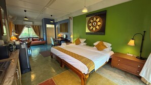 A hotel room with a bed, desk, chair, and a view of the outdoors. - Golden Mango House (Sam Roi Yot)