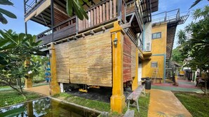 A building with a multi-level structure, outdoor seating, and a small water feature. - Golden Mango House (Sam Roi Yot)