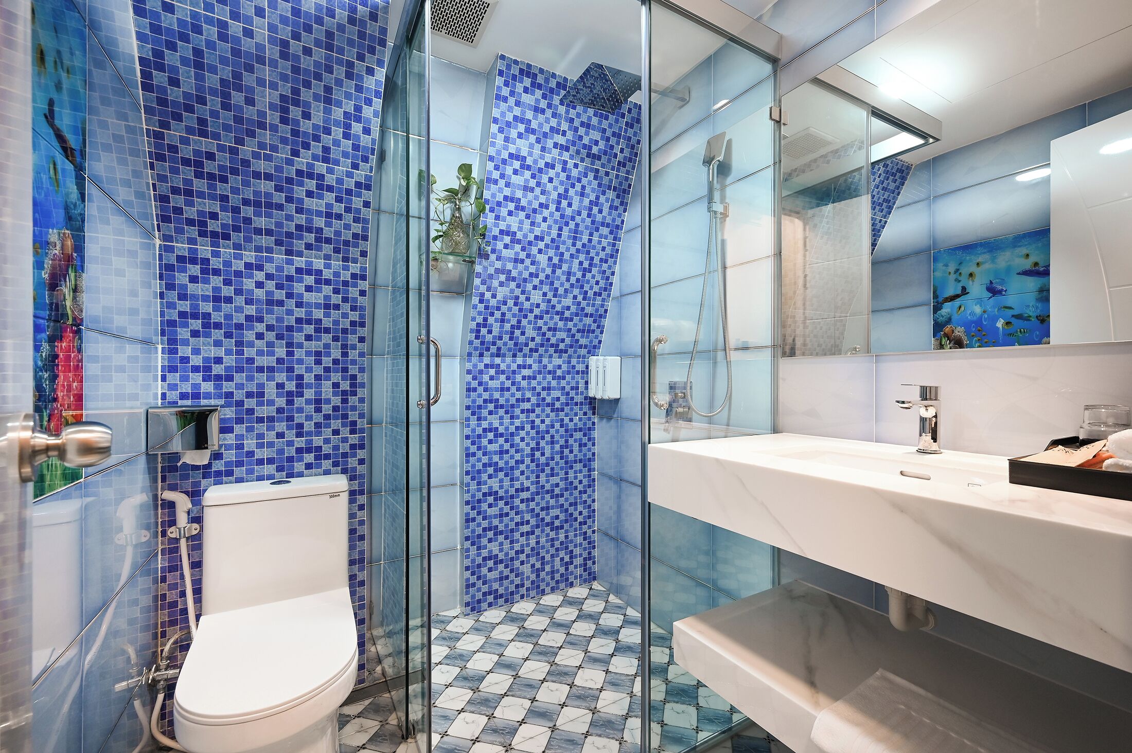 Une salle de bain avec une douche à parois de verre, des toilettes blanches et un lavabo avec un miroir.