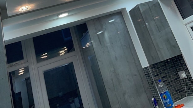 A ceiling with multiple recessed lights and a central chandelier.