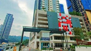 Un moderno edificio de gran altura con una entrada destacada y un cartel de bienvenida.