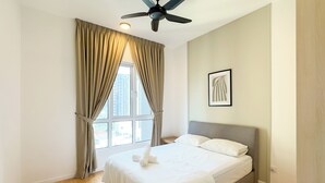 Un dormitorio con cama, ventilador de techo, ventana con cortinas e imagen enmarcada en la pared.