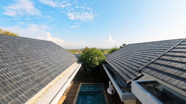 A rooftop with solar panels, a swimming pool, and a view of the cityscape.