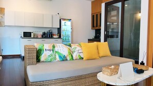 Una habitación acogedora con sofá, una mesita y una cocina al fondo.