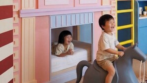 Ein Kinderspielbereich mit einem Etagenbett und einem Spielhäuschen.