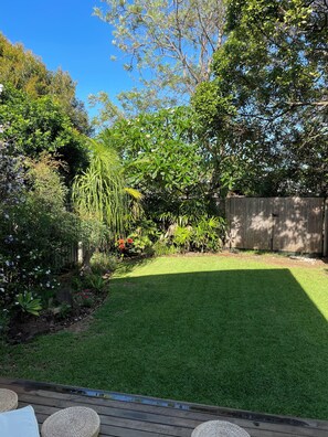 Relax in a serene garden setting with a wooden deck and comfortable seating.