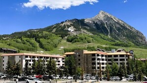 Ein Hotel mit mehreren Etagen, Parkplatz und Bergblick.