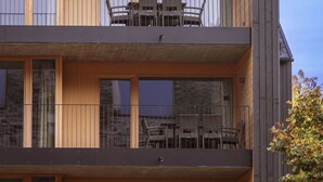 A modern multi-story building with a wooden facade and large windows.