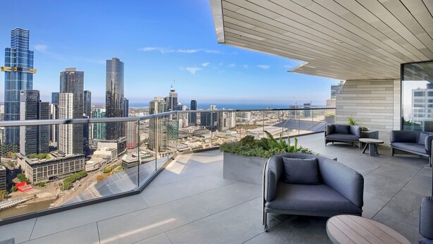 A modern balcony with a city view, furnished with sofas and a table, and a glass railing. - Melbourne Corporate Apartments – Collins Street (Melbourne)