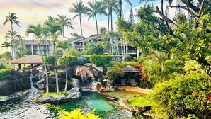 Um resort tropical com cachoeira, vegetação exuberante e área de piscina.