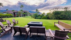 Resort com área de estar ao ar livre, lareira e vista para montanhas e palmeiras.
