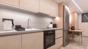 Une cuisine moderne équipée d’un réfrigérateur en acier inoxydable, d’un four encastré, d’une machine à café et d’un évier.