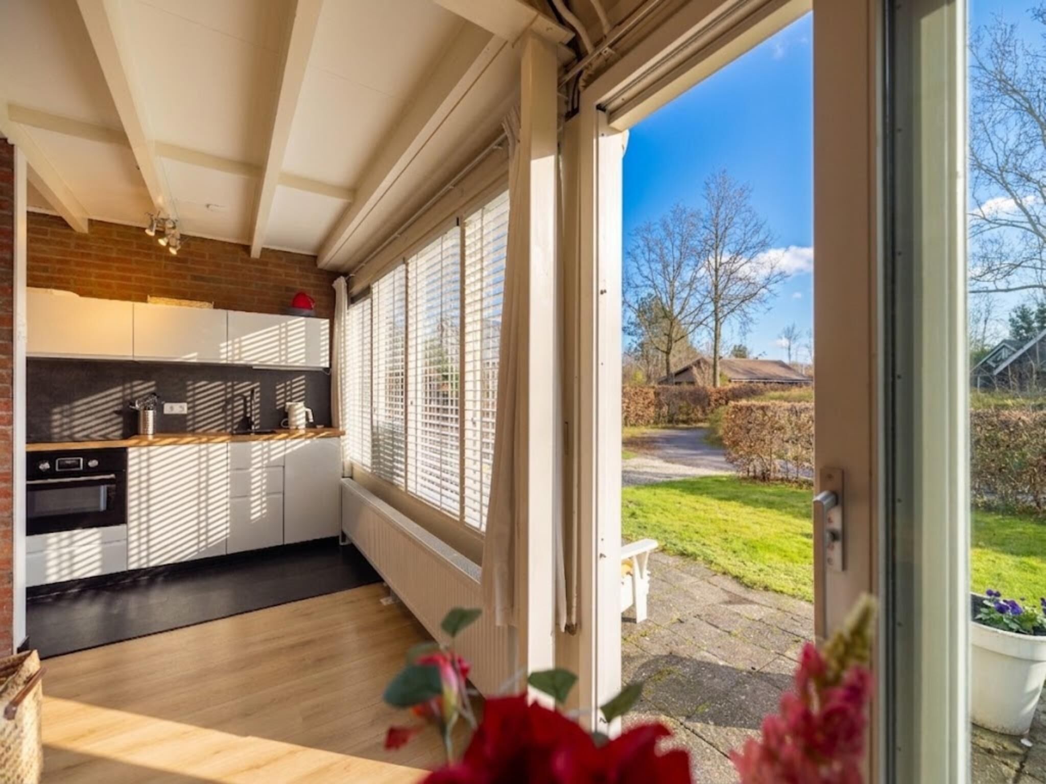 Een moderne keuken met een groot raam, een eethoek en uitzicht op het landschap.