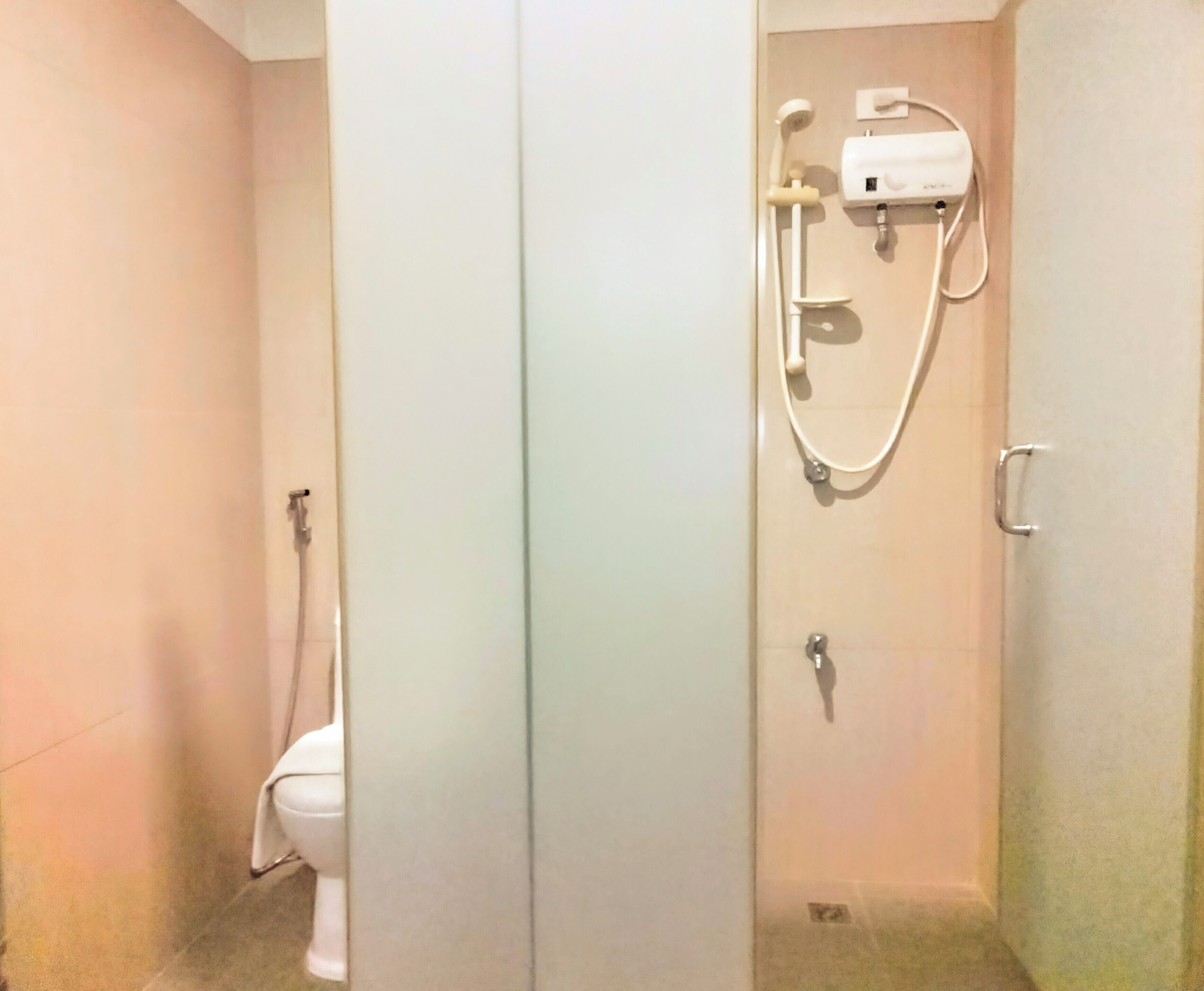 A bathroom with a toilet, a shower, and a sink.