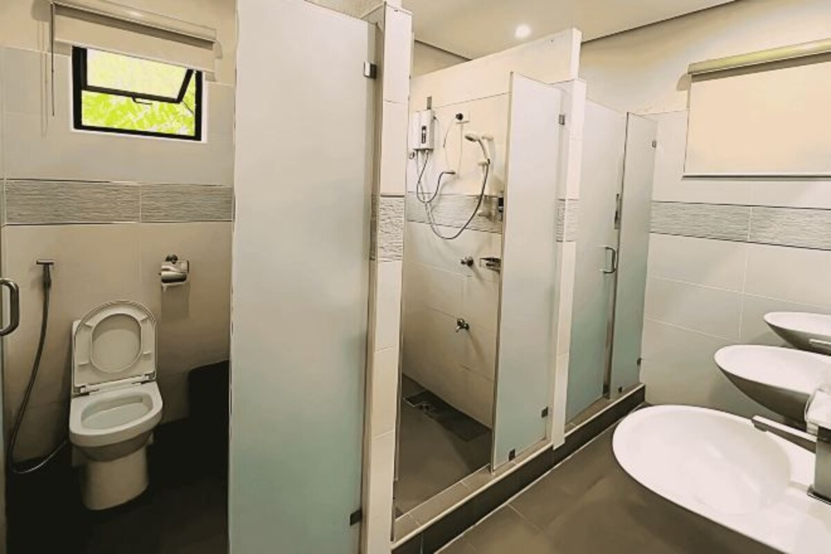 A modern bathroom with a toilet, a shower enclosure, and a sink.