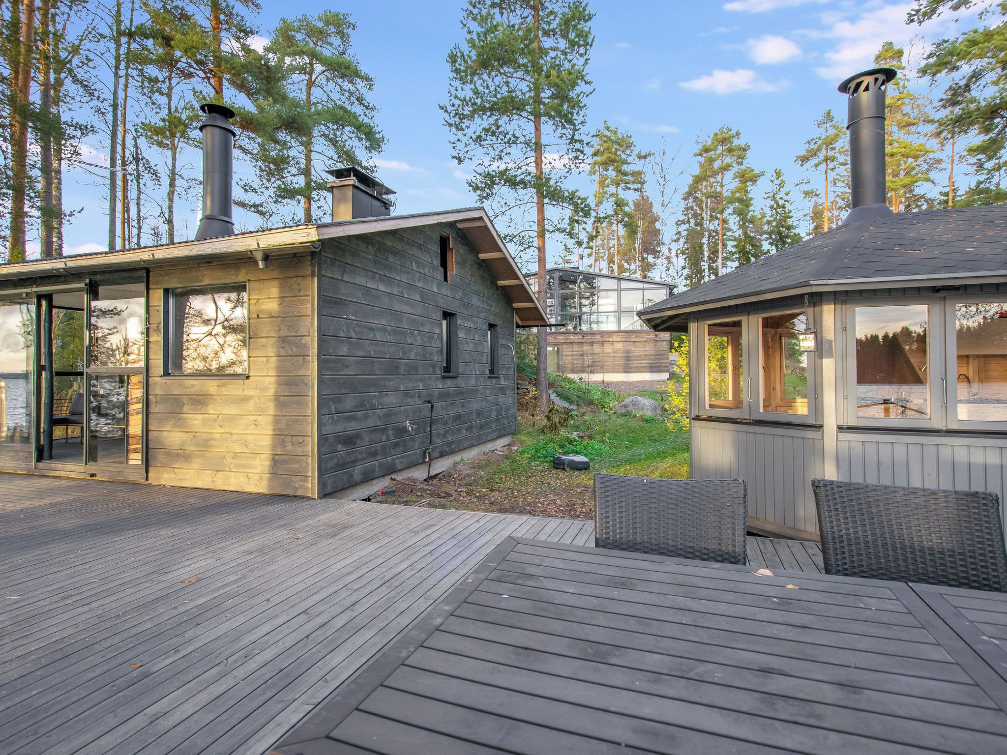 A modern cabin with a deck, large windows, and a sauna area.