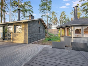 A modern cabin with a deck, large windows, and a sauna area. - Villa milla by Interhome (Mäntyharju)