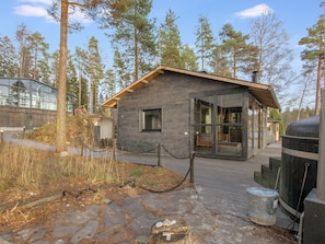 Una cabaña con base de piedra, fachada de madera y grandes puertas de cristal.