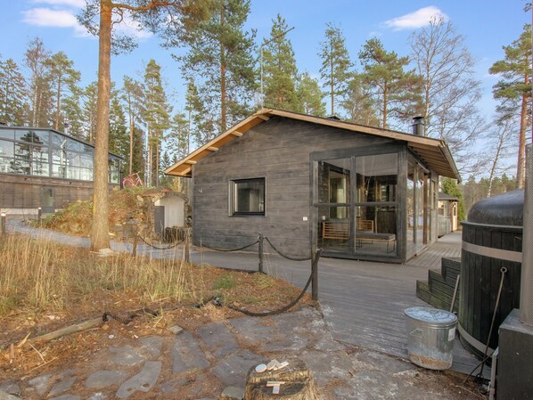 Eine Holzhütte mit steinernen Fundamenten und großen Glasfenstertüren.