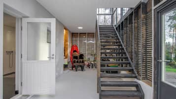 Ein modernes Interieur mit einer Treppe, einer Tür zu einem Badezimmer und einem roten Kajak.