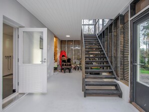 Un intérieur moderne avec un escalier, une porte donnant accès à une salle de bain et un kayak rouge.