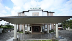 A hotel entrance with a covered walkway, a sign reading "PARKSIDE," and a paved driveway. - Parkside Meuligoe Hotel (Meulaboh)