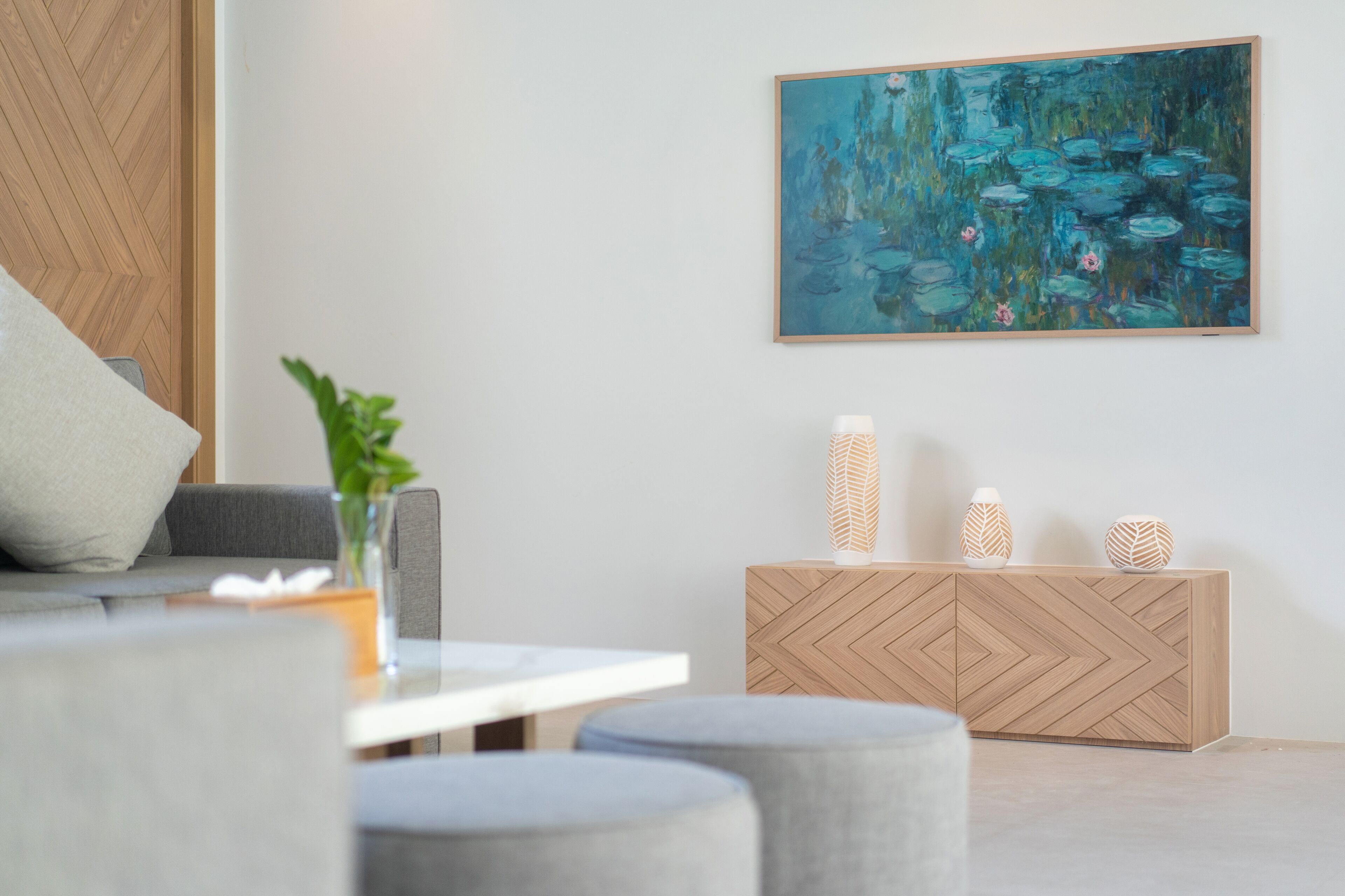 Ein modernes Wohnzimmer mit einer Couch, einem Couchtisch und einer Anrichte mit Dekorationselementen.