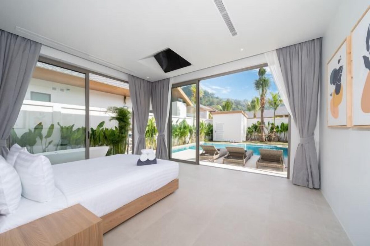 Un dormitorio moderno con una cama grande y puertas de cristal correderas que dan a una zona de piscina.