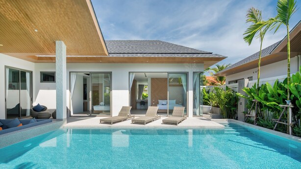 A modern pool area with clear blue water, lounge chairs, and a wooden pergola. - Himmapana Villas - Grand Valley (Kamala)