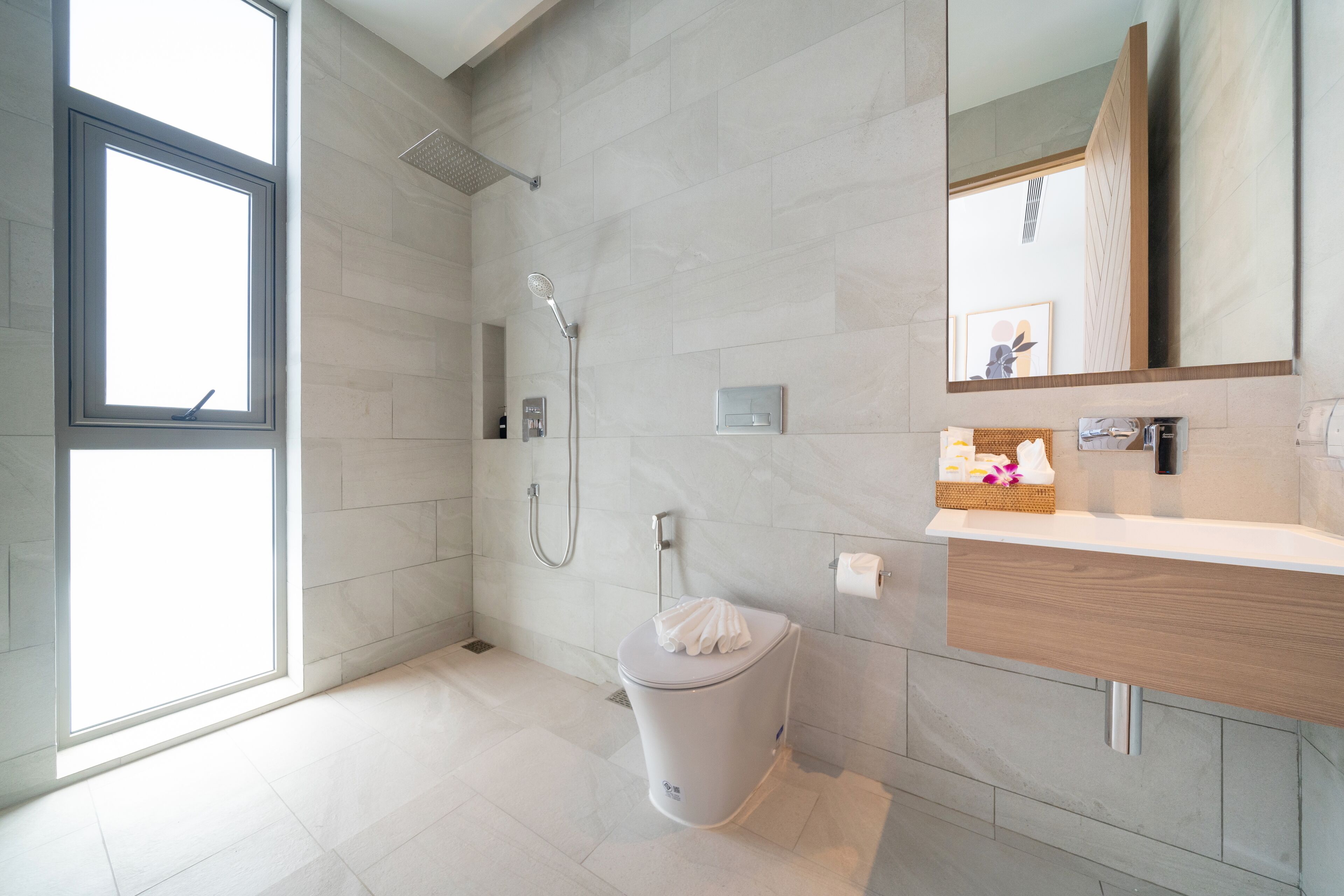 Une salle de bain moderne équipée d’une douche, de toilettes et d’un meuble-lavabo.