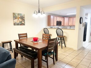 A dining area with a wooden table and chairs, a red bowl on the table, and a painting on the wall. - Mountain View Condos - Unit 5106 (Pigeon Forge)