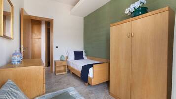 A bedroom with a wooden bed, a wardrobe, a bedside table, and a mirror.