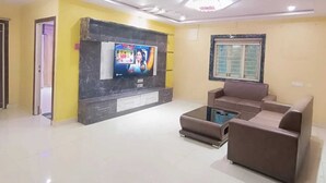 Una sala de estar moderna con un televisor de pantalla plana, un sofá y una mesita de centro.