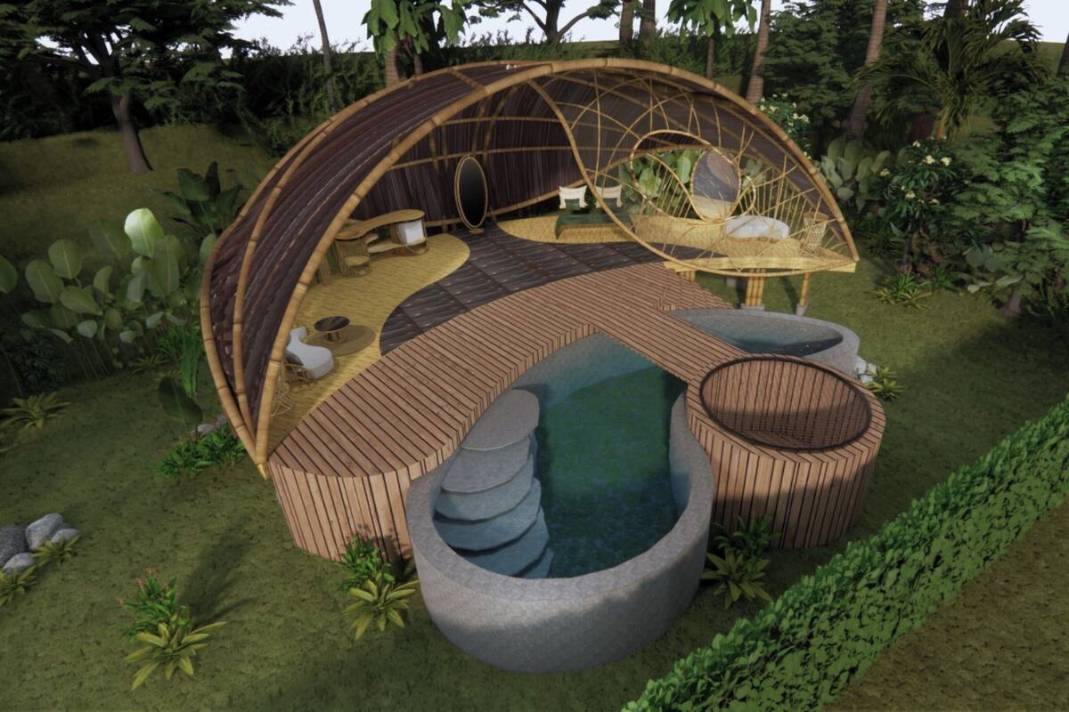 Una estructura circular al aire libre con techo de paja, un espacio central para sentarse y un pequeño elemento acuático.