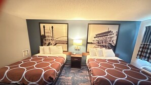 A hotel room with two beds, a nightstand, a lamp, and two wall-mounted pictures. - Northwood Inn Prairie Du Chien (Prairie Du Chien)
