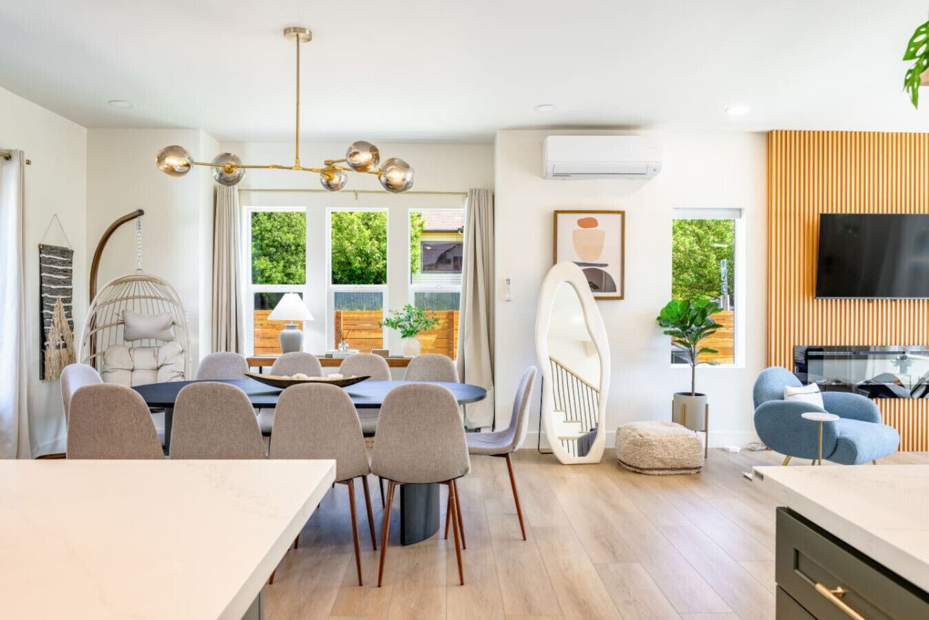 Un salon moderne équipé d’un téléviseur, de sièges et d’un coin repas avec une table et des chaises.