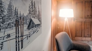 Een kamer met een muurschildering over skiën, een houten deur en een vloerlamp.