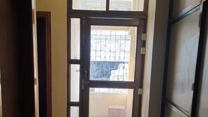 A hallway with a wooden door leading to a balcony.