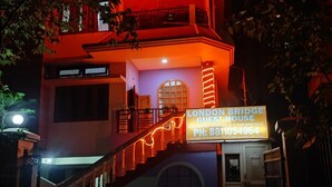 A building with a sign reading "LONDON BRIDGE GUEST HOUSE" and a staircase leading up to the entrance.