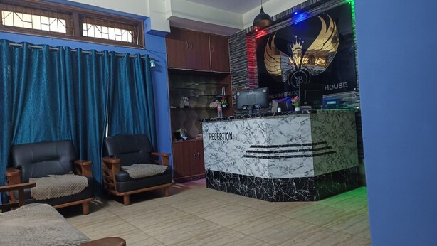 A reception area with a marble counter, a black leather chair, and a blue curtain.