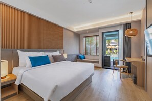 Une chambre d’hôtel moderne dotée d’un grand lit, d’un bureau et offrant une vue sur l’espace extérieur de la piscine.