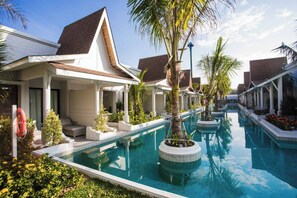 A poolside area with multiple lounge chairs and a clear blue pool. - Lalynn Resort & Villas, Phuket (Thep Krasattri)